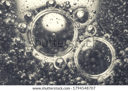 Abstract macro photo of oil bubbles. Oil and water backgroung with one source of light