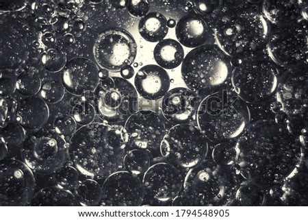 Abstract macro photo of oil bubbles. Oil and water backgroung with one source of light