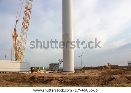 Wind turbine construction site, installation of a windmill crane. Ecological energy, modern technologies, construction of wind generators. Royalty-Free Stock Photo #1794605566