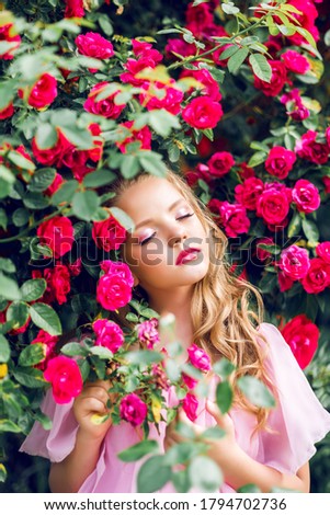 portrait of a young girl with closed eyes against a background of pink roses