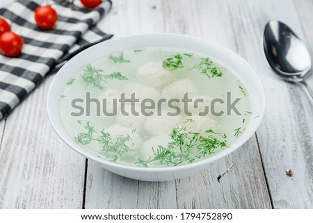 Chicken soup bouillon in a plate with meatballs