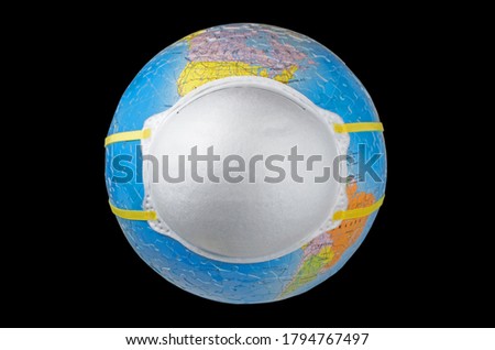 A face mask (N95) putting on a world globe protecting the world from pollution and infectious diseases (closeup, isolated on black background) Royalty-Free Stock Photo #1794767497