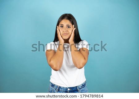 Young beautiful woman  standing over isolated blue background suffering from headache desperate and stressed because pain and migraine with her hands on head