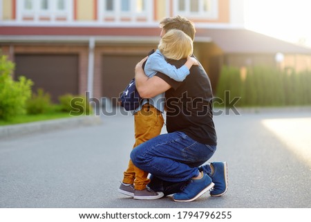 Little boy says goodbye and hugging to his father before going to school. Education for children. First day of school. Child's fear. Royalty-Free Stock Photo #1794796255