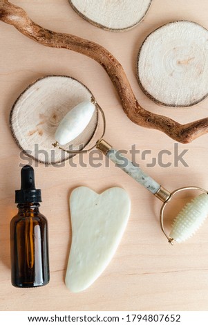 Facial massage roller and guache scraper on wood background. Advertising Beauty salon, face massage. Place for the text. Stock photography