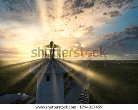 LIGHTHOUSE AERIAL SHOT WITH SUNBEAMS AT SUNSET