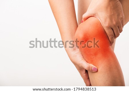 Closeup young Asian woman joint holding her painful knee, studio shot isolated on white background, Healthcare medical and hygiene arthritis problems care concept