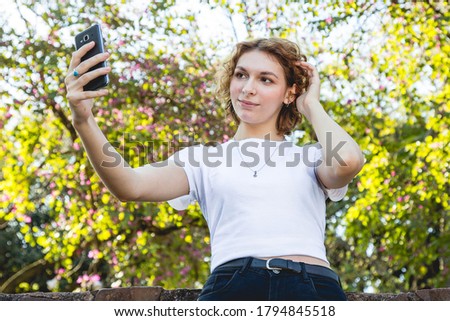 young woman takes a picture with her cell phone