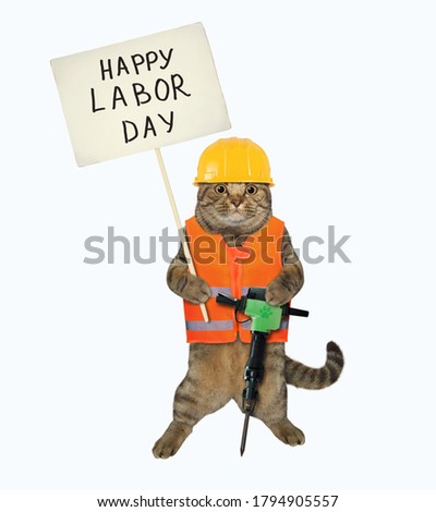 The beige cat worker in a vest, a helmet and shoes is holding a jack hammer and a sign Happy Labor Day. White background. Isolated.