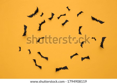 Flying bats on yellow background. Halloween background. Top view. Flat lay