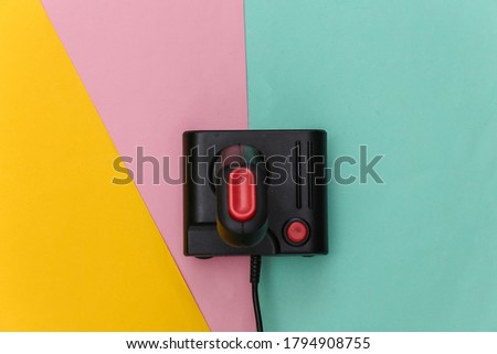 Wired retro joystick on colored background. Video game, gaming. Top view