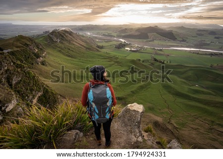 Woman backpacker standing at the top of Te Mata Peak in Hawke's Bay, New Zealand. Traveler concept