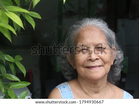 Elderly filipino woman smiling to the camera Royalty-Free Stock Photo #1794930667