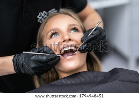 Beautiful woman patient having dental treatment at dentist's office.