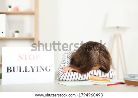 Sad girl holding a stop bullying sign
