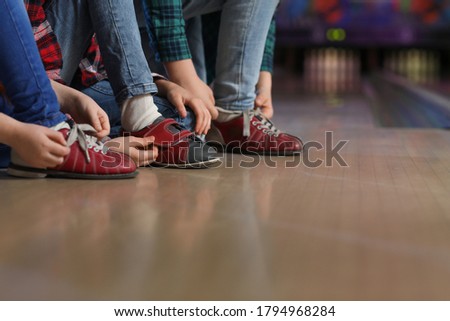 Little children tying shoelaces in bowling club