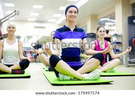 group of young women doing yoga in  gym