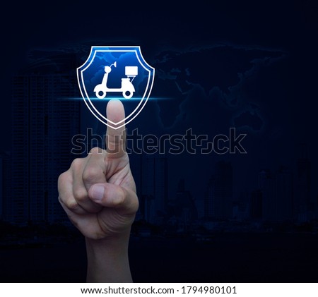Hand pressing motorcycle with shield flat icon over world map, modern city tower and skyscraper, Business motorbike insurance concept, Elements of this image furnished by NASA