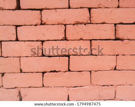 A Brick texture made on a wall using natural bricks of red color.The bricks are arranged in an order and looks attractive.The arrangement have a well designed pattern.
