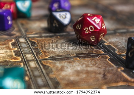Red d20 die showhing a 20. Set of role playing dice on a gaming mat.  Royalty-Free Stock Photo #1794992374