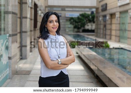Portrait of confident Indian business woman in corporate building. Smiling female wearing smart formal attire. Royalty-Free Stock Photo #1794999949
