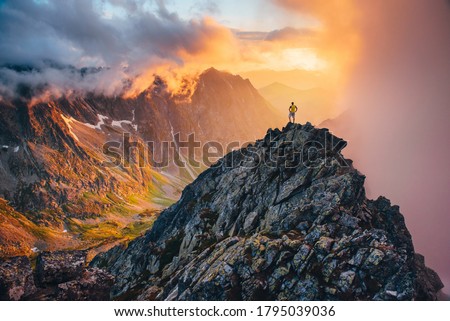 Man on the top of the hill watching wonderful scenery in mountains during summer colorful sunset in High Tatras in Slovakia Royalty-Free Stock Photo #1795039036