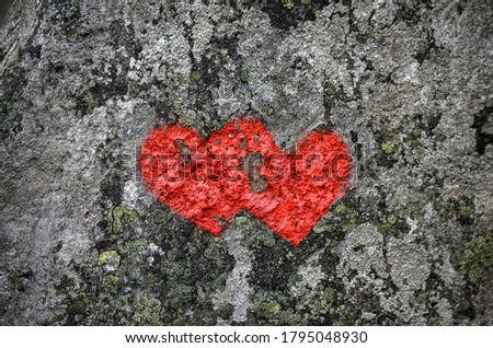 Two red hearts are painted in stone
