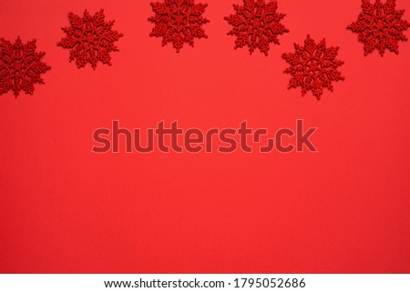 Christmas decorations. Red snowflakes on the red background with copy space. New year card.