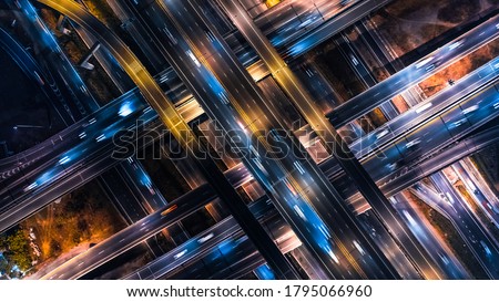 Top view of car traffic transport on crossing multiple lanes highway or expressway in Asia city at night. Civil engineering, technology background, Asian transportation concept