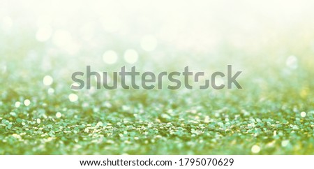 Defocus Abstract light blur blink sparkle horizontal backgound. Green glitter shine dots confetti.