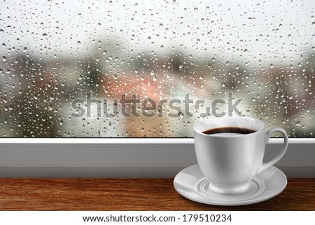 Coffee cup against window with rainy day view