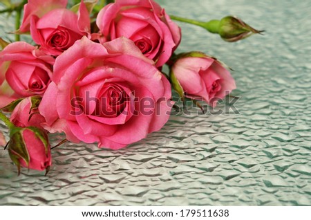 Pink rose flowers on uneven glass background