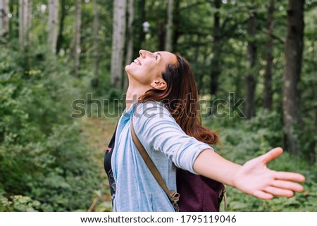Woman forest bathing with arms outstretched enjoying nature adult caucasian woman in nature practising yoga breathing exercise in forest Royalty-Free Stock Photo #1795119046