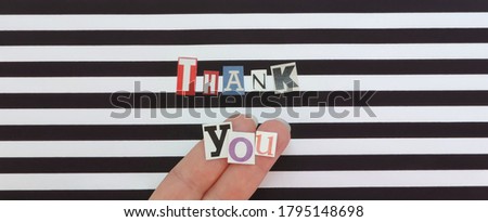      thank you words made from paper letters cut from magazines on a striped black and white surface . Selective Focus          