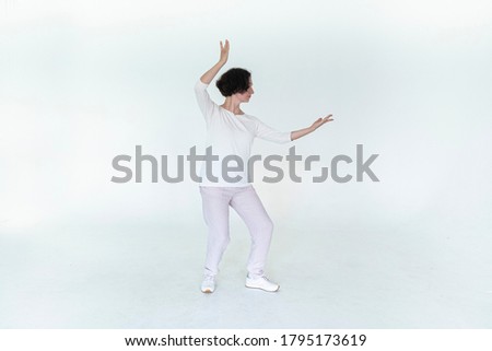 woman practicing qi qong at white studio traditional chinese gymnastics	