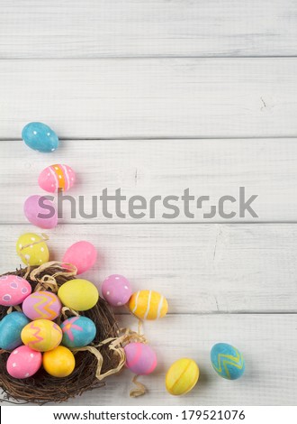 Colorful Easter Eggs in Nest from Top Side View on White or Gray Rustic Wood Background with room or space for copy, text, words 
