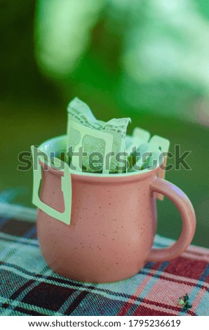Filter coffee in pink colored cup, coffee cup standing on table. Scenic view, in the forest