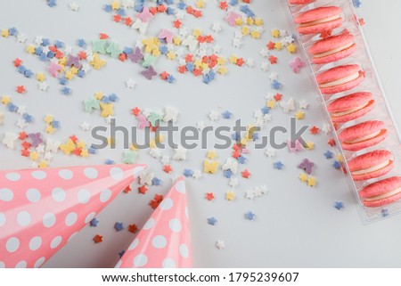 Party hats with sugar sprinkles, cookies flat lay on a white background 