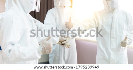 Doctor and medical technicians in protective disease PPE suit uniform and face mask Hands Together Joining Concept Royalty-Free Stock Photo #1795239949