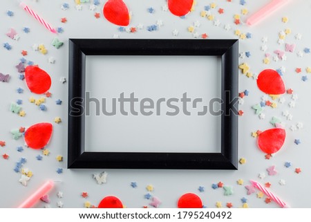 Frame with sugar sprinkles, candles, petals flat lay on a white background 