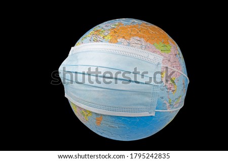A surgical face mask putting on a world globe protecting the world from pollution and infectious diseases (closeup, isolated on black background) Royalty-Free Stock Photo #1795242835