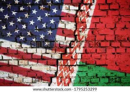 Brick wall with a flag of Belarus and the USA with a big crack in the middle. Concept of sanctions and political problems between countries