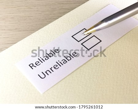 One person is answering question on a piece of paper. The person is thinking to be reliable or unreliable. Royalty-Free Stock Photo #1795261012