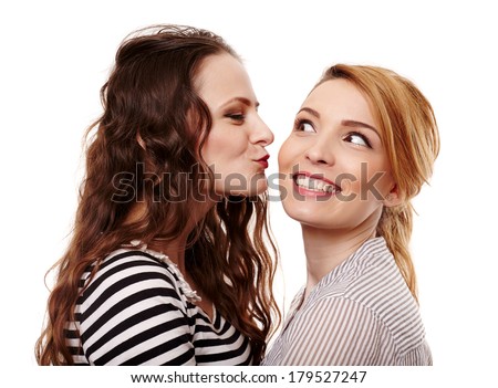 Two girlfriends having fun and kissing on the cheek