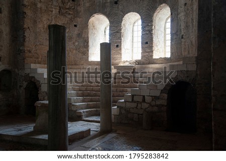 Column hall made of stone in some old castle or church with arches and okras Royalty-Free Stock Photo #1795283842