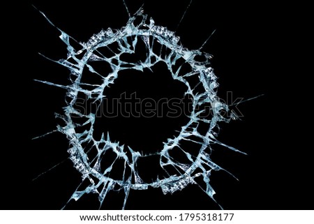 pattern from the impact of a broken mirror and glass on a black background in cracks in the form of an isolated image abstraction