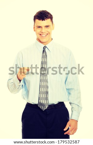 Young happy smiling successful business man with blank business card or sign 