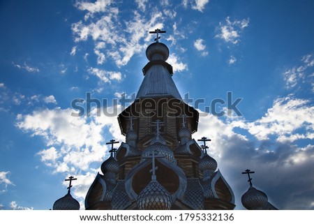 large horizontal photo. summer time. Russia. Belgorod. Christian temple against the backdrop of a beautiful blue sky with white clouds. the roof of the temple. wooden domes. Orthodox cross.