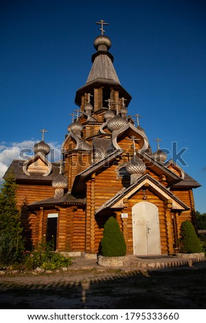 large vertical photo. summer time. Russia. Belgorod. Christian temple against the background of a clear blue sky. wooden domes. Orthodox cross. sunset light. Orthodox Church.