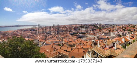Panorama shot of the roofs of Lisbon, Portugal. With the river and the bridge in the background.